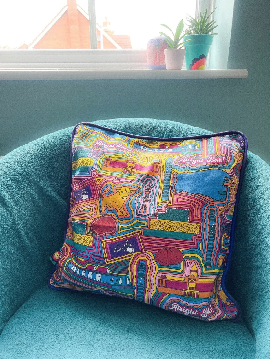patterned birmingham printed pillow sitting on blue chair