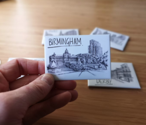 hand holding a white and black birmingham magnet
