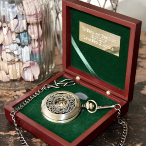 gold pocket watch sat in wooden box with green lining